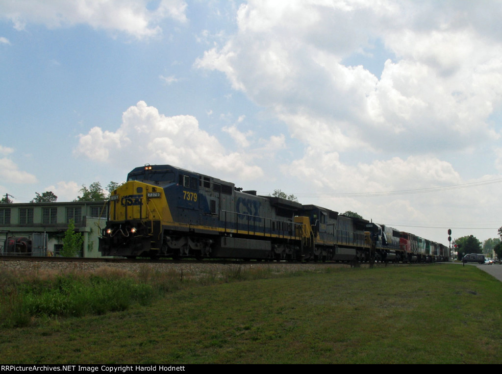 CSX 7379 leads a long train thru town